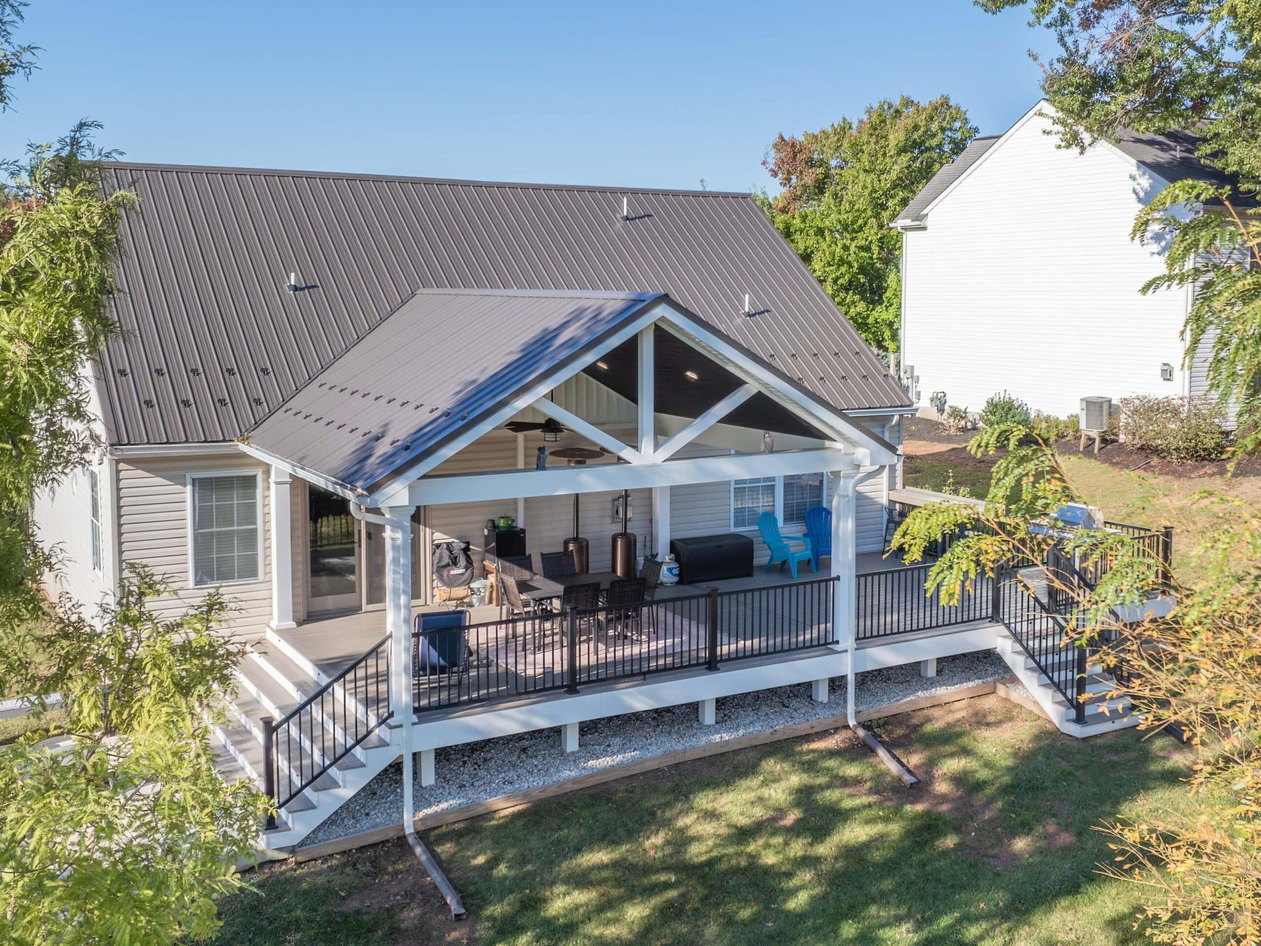 deck with pavilion and large set of steps down to a patio