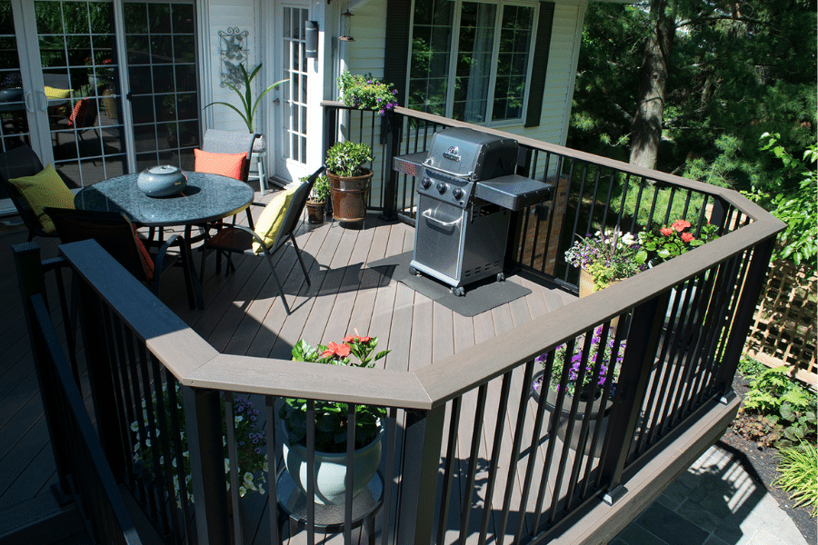 brown vinyl decks with curved railings in PA with outdoor table chairs and grill