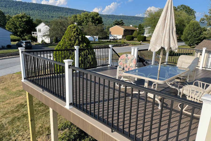 composite deck in backyard with porch table and chairs around it