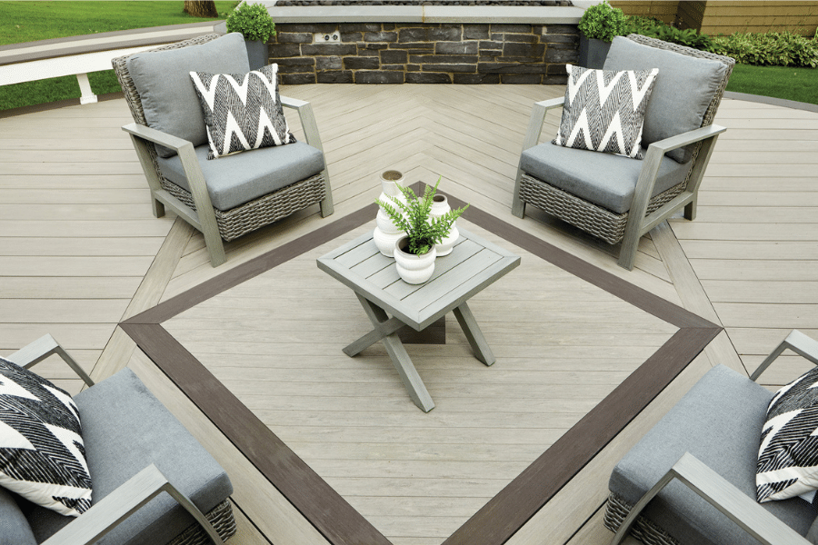 composite woode decking materials tan and dark gray creating square with table in center and porch chairs around it